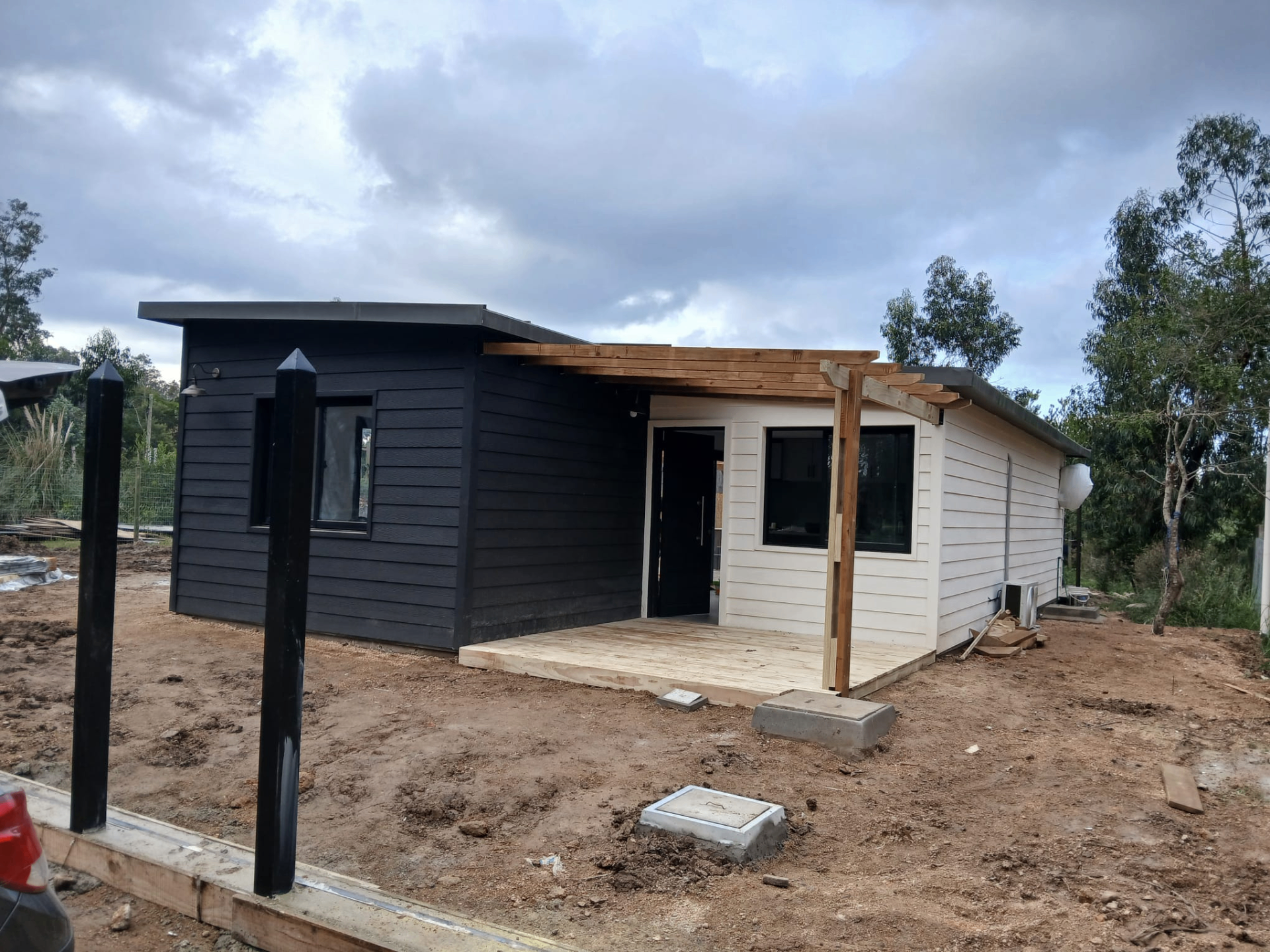 Fachada terminada con pérgola de madera