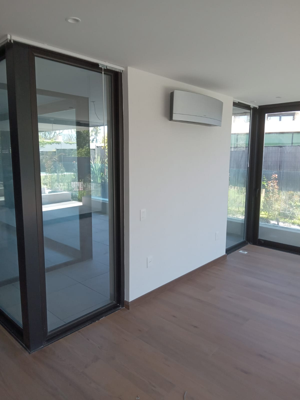 Living con ventanales y piso de madera